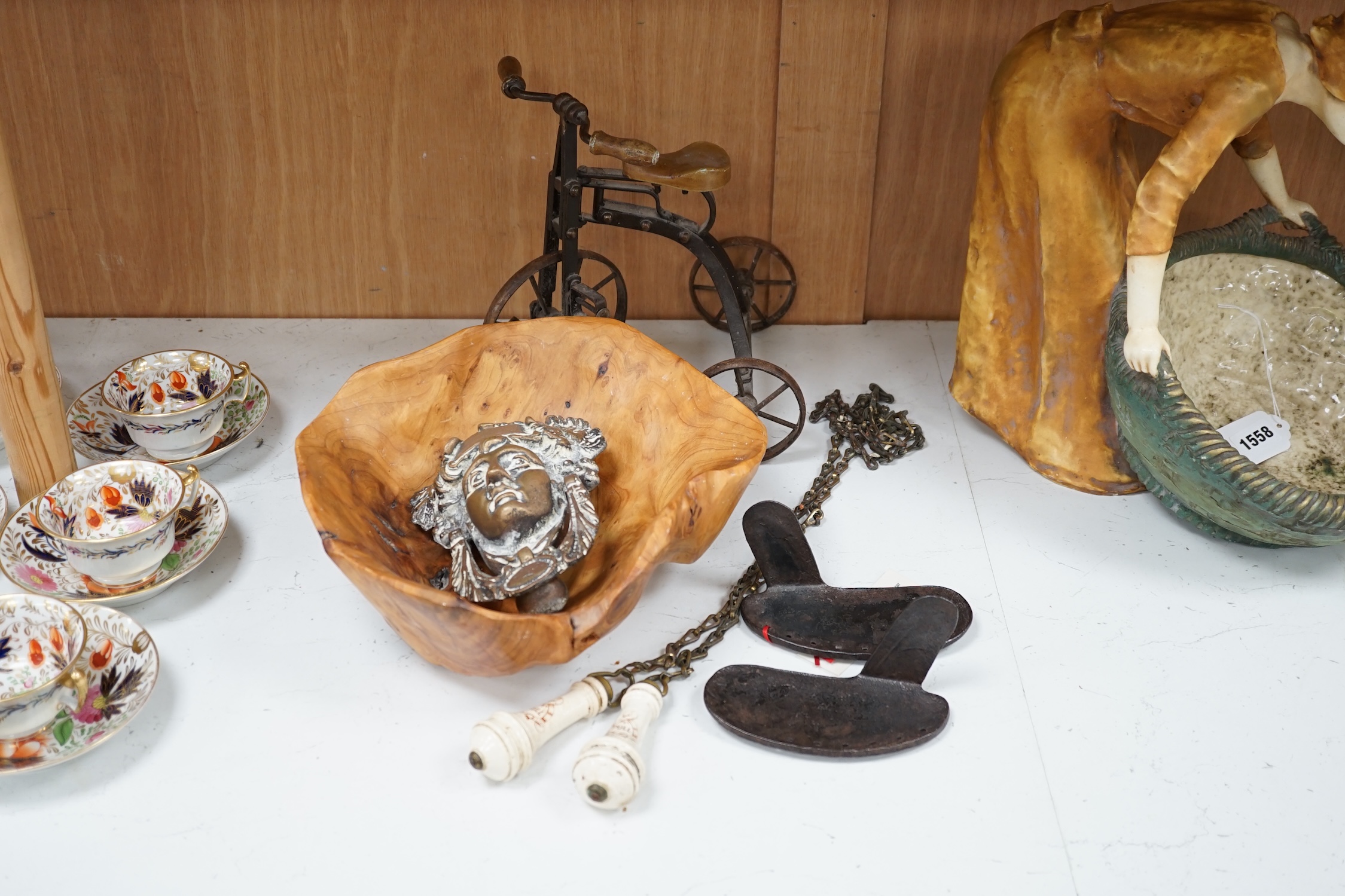 A cast iron toy model of a tricycle, a carved wooden bow, a classical figurative door knocker, a pair of metal cow shoes and two ceramic cistern pulls, bowl 30cm diameter. Condition - fair